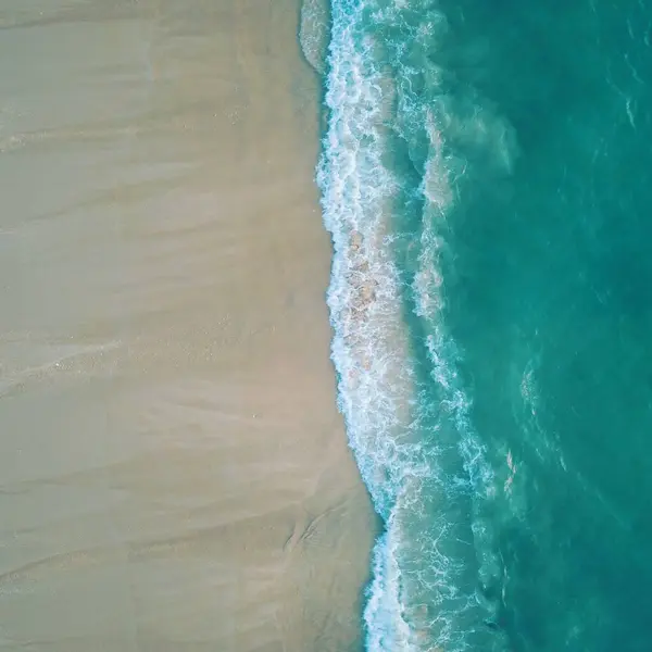 Kumsalın üst manzarası ve kumdaki dalga.