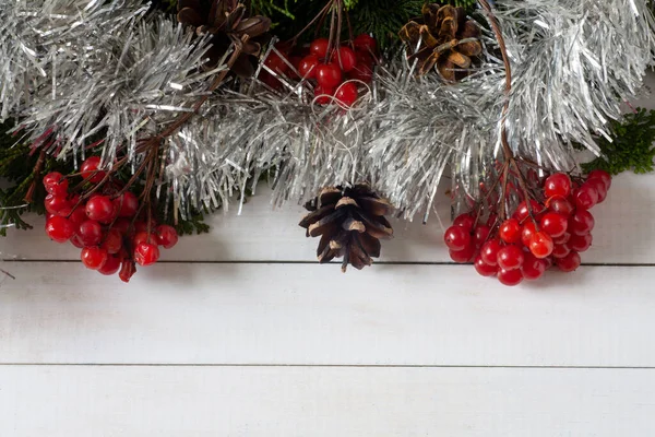 Beyaz arka planda, bir Noel ağacının dalları, koniler ve viburnum üzümleri. Boşluğu kopyala.