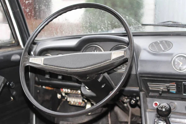 Steering wheel of an old car. Against the background of the instrument panel. local focus.