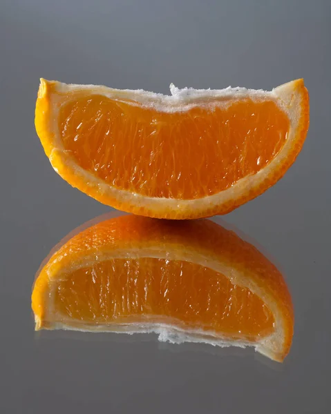 镜面桌上有一片橙子 从哪里来的反思 — 图库照片