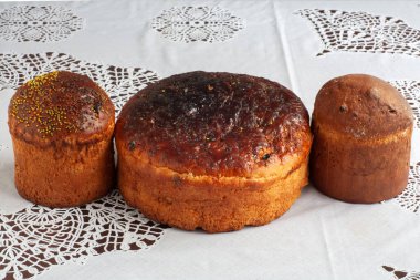 Masada beyaz bir masa örtüsünün üzerinde üç Paskalya bayramı var. Bir büyük ve iki küçük..