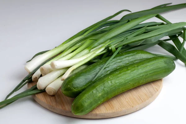Table Two Cucumbers Green Onions White Background — Stock Photo, Image
