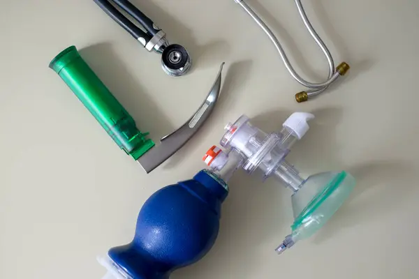 Masanın üzerinde bir laringoskop, bir Ambu torbası ve bir fonendoskop var. Yatay çekim.