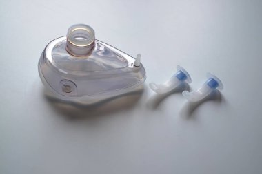 Masada bir oksijen maskesi ve iki tıbbi havalandırma kanalı var. Hafif bir arkaplanda.