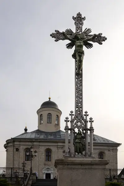 Demir haç kilisenin önünde. Gri gökyüzünün arka planında.