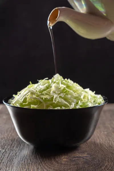 Parçalanmış lahana tabakta. Üzerine yağ serpiştirilmiş. Sağlıklı beslenme. Alçak tuş.