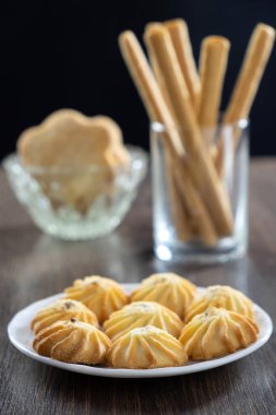 Masada farklı türde kurabiyeler var. Siyah bir arka planda. Seçici odak.