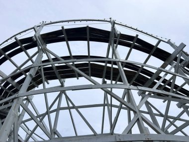 İp ışıkları ve bulutlu gökyüzü olan beyaz ahşap lunapark treni 