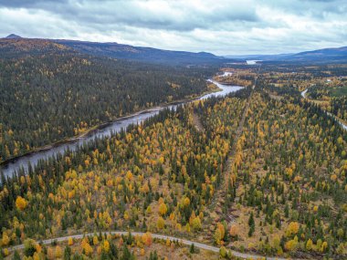 Gautstraesk Gölü 'ne akan ve Laponya' daki Ammarnas Ulusal Parkı boyunca uzanan nehir kenarındaki kamp kervanı manzarası.