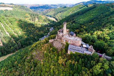 Ortaçağ şatosu Ehrenburg 'da Brodenbach' taki Moselle nehrinin yanında orman tepeleri olan hava manzaralı bir kaya..