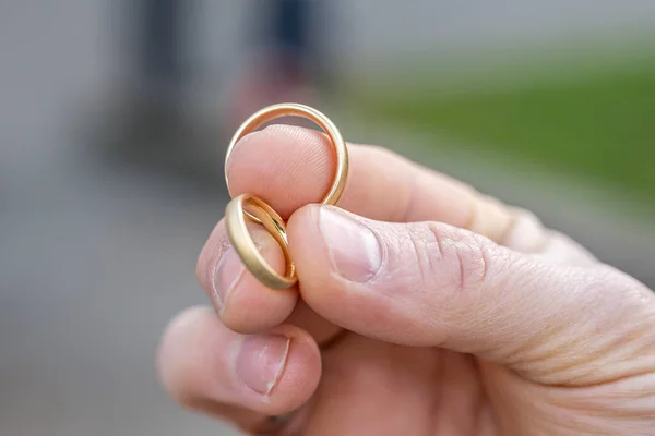 Mužských Prstech Jsou Dva Snubní Prsteny Svatební Tradice Zlaté Prsteny — Stock fotografie