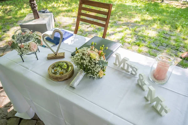 美丽的婚宴桌上 先生和小姐在背景花束和结婚戒指的衬托下 签了字 — 图库照片