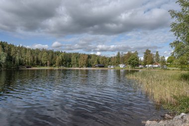 Dalsland İsveç 'te Ragnerudsjoen Gölü' nün kıyısındaki kamp alanı karavanı. Güzel doğa ormanı çam ağaçları..