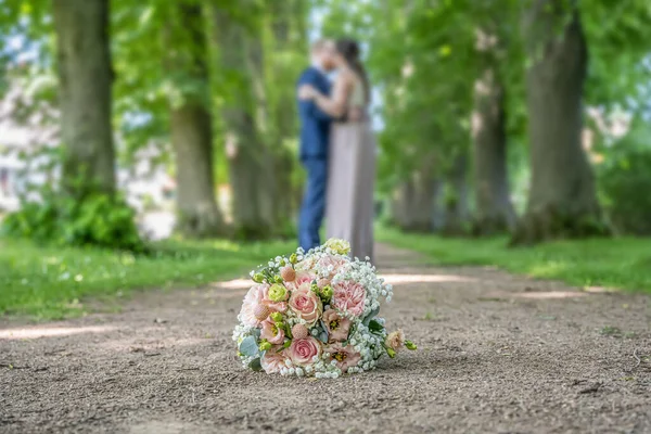 Esküvői Csokor Előterében Egy Elmosódott Csók Pár Virágok Szerelmesek — Stock Fotó