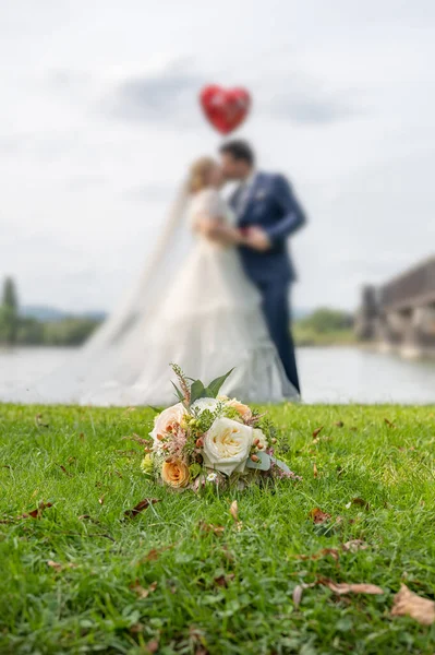 Hochzeitsstrauß Vordergrund Eines Verschwommenen Küssenden Paares Blumen Und Liebhaber — Stockfoto