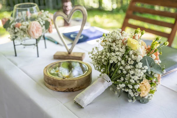 Krásný Svatební Stůl Povrch Proti Pozadí Kytice Květin Snubních Prstenů — Stock fotografie