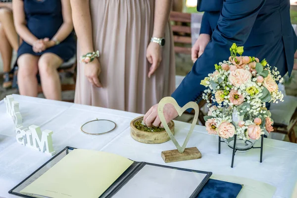 美丽的婚宴桌上 先生和小姐在背景花束和结婚戒指的衬托下 签了字 — 图库照片