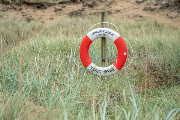 一个救生圈的标志矗立在瑞典梅尔比斯群岛的沙丘上 — 图库照片