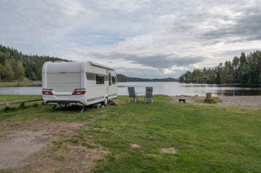 Dalsland İsveç 'te Ragnerudsjoen Gölü' nün kıyısındaki kamp alanı karavanı. Güzel doğa ormanı çam ağaçları..