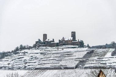Moselle Nehri üzerindeki tepelere kurulmuş Mosel üzüm bağlarındaki Burg Thurant Şatosu 'ndaki Kış Harikalar Diyarı Almanya' nın Alken kasabası