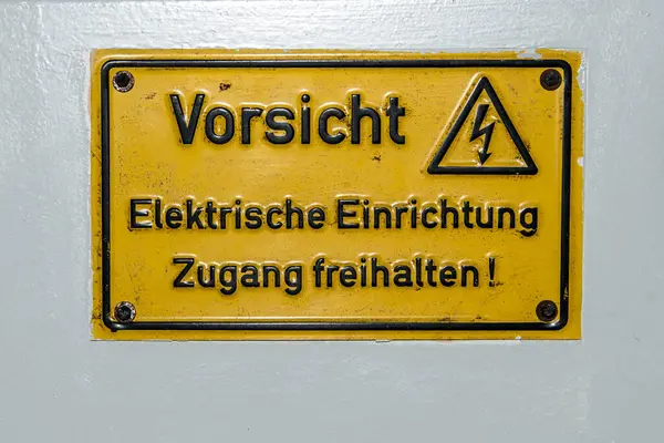 High Voltage Sign Warning in German saying Electric device do not cover on Electric Control Box.