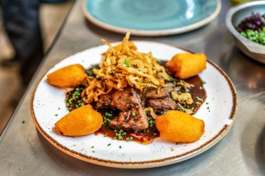 Kızarmış mini patates, rosmarine ve beyaz tabakta karaciğer eti..