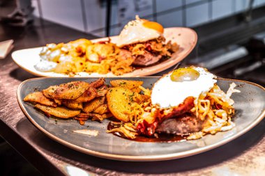 Alman usulü kızarmış patates ya da domuz pastırması ve soğanlı Bratkartoffeln masanın üzerindeki tabağa yakın..