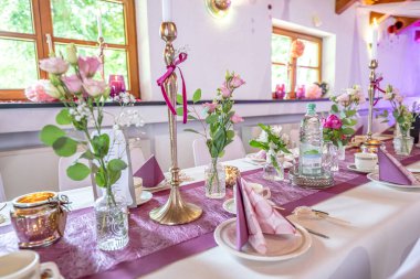 Düğün dekoru. Düğün masasının dekorasyonunu beyaz, pembe çiçekler ve mumlarla kapat. Düğün çiçeği konsepti