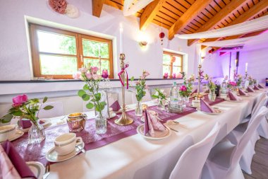 Düğün dekoru. Düğün masasının dekorasyonunu beyaz, pembe çiçekler ve mumlarla kapat. Düğün çiçeği konsepti