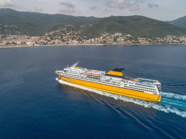 Büyük sarı yolcu feribotu Akdeniz 'e gidiyor. Korsika adası yakınlarında, Fransa hava manzaralı Bastia limanı..
