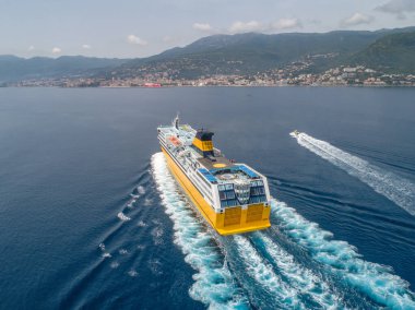 Büyük sarı yolcu feribotu Akdeniz 'e gidiyor. Korsika adası yakınlarında, Fransa hava manzaralı Bastia limanı..