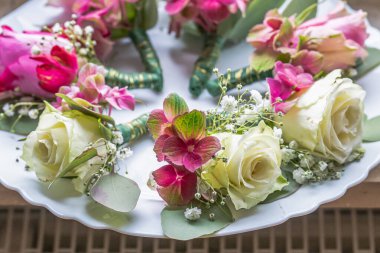 Beyaz mermer tabakta küçük şık yaka çiçekleri, düz, renkli pek çok damat yatıyordu. .