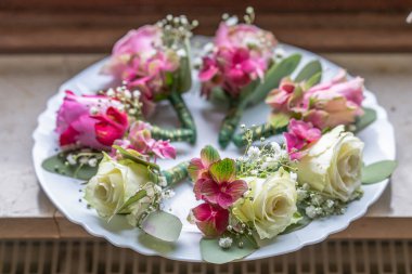 Beyaz mermer tabakta küçük şık yaka çiçekleri, düz, renkli pek çok damat yatıyordu. .