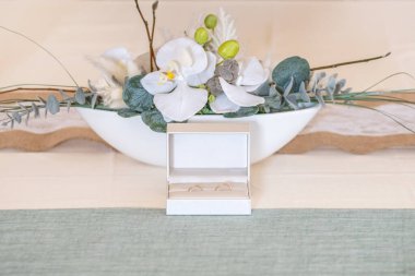 Zarif altın alyanslar yumuşak saten beyaz kurdelelerin arasındadır. Ön dikey görünüm. Düğün tasarımı için maket. Kartpostal davet