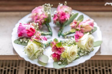 Beyaz mermer tabakta küçük şık yaka çiçekleri, düz, renkli pek çok damat yatıyordu. .