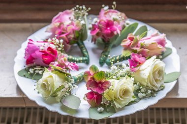 Beyaz mermer tabakta küçük şık yaka çiçekleri, düz, renkli pek çok damat yatıyordu. .