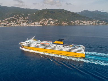 Büyük sarı yolcu feribotu Akdeniz 'e gidiyor. Korsika adası yakınlarında, Fransa hava manzaralı Bastia limanı..