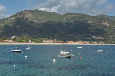 Sagone Korsika 'daki muhteşem golf sahili güzel kumsal tekneleri ve dağ köyü turizmi ve tatil konsepti