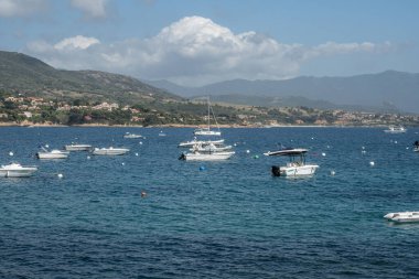 Sagone Korsika 'daki muhteşem golf sahili güzel kumsal tekneleri ve dağ köyü turizmi ve tatil konsepti