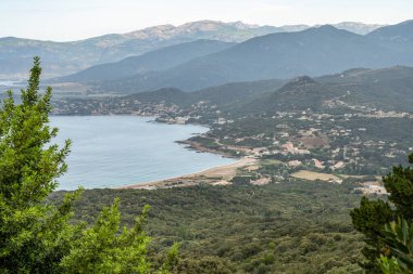 Sagone Korsika 'daki muhteşem golf sahili güzel kumsal tekneleri ve dağ köyü turizmi ve tatil konsepti