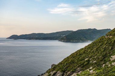 Fransa Korsika adasındaki Cap Corse yarımadasının kayalık kıyıları boyunca kıyı şeridi manzaralı yol.