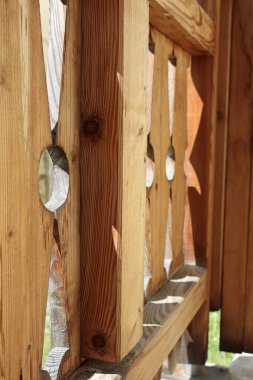 Ahşap korkuluklara yakın çekim, oyulmuş desenler ve güneş ışığı gölgeleri. Sıcak ahşap dokusu ve çizgileri rahat ve doğal bir his yaratır..