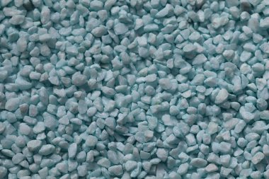 Açık mavi dekoratif çakıl taşlarına yakın çekim. Akvaryumlarda, peyzajda, el sanatlarında ya da ev dekorasyonunda kullanılmak için ideal. Küçük ezilmiş taş parçalarıyla soyut arkaplan dokusu.