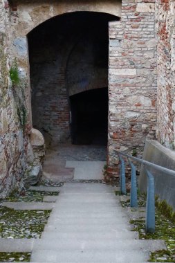 Eski taş merdiven karanlık bir ortaçağ tüneli girişine çıkıyor. Tarihi tuğla duvarlar ve yosun kaplı basamaklar gizemli bir antik atmosfer yaratır..