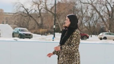 Mutlu aşıklar buz pateni pistinde birbirlerine doğru kayıyor ve kucaklaşarak dönüyorlar. Sevgili çift soğuk kış gününde eğleniyor. Yüksek kalite 4k görüntü