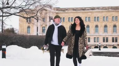 Buz pistinde yürüyen patencilerle el ele tutuşan mutlu çift. Yüksek kalite 4k görüntü