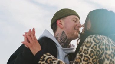 Mutlu genç ve güzel çift güneşli kış ormanlarında birlikte vakit geçirir. Erkek ve kadın birlikte durur, gülümser, burunlara dokunur, öpüşürler. Karlı parkta romantik bir randevu. Yüksek kalite 4k görüntü