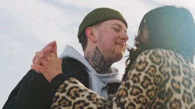 Mutlu genç ve güzel çift güneşli kış ormanlarında birlikte vakit geçirir. Erkek ve kadın birlikte durur, gülümser, burunlara dokunur, öpüşürler. Karlı parkta romantik bir randevu. Yüksek kalite 4k görüntü