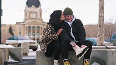 İki birey karlı bir şehir gezintisinden zevk alıyor. Şık bir leopar kürkü ve buz pateni büyüleyici tarihi bir bina ve kış atmosferi tarafından çerçevelenmiş bir cazibe ekler. Yüksek kalite 4k görüntü