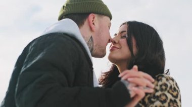 Mutlu genç ve güzel çift güneşli kış ormanlarında birlikte vakit geçirir. Erkek ve kadın birlikte durur, gülümser, burunlara dokunur, öpüşürler. Karlı parkta romantik bir randevu. Yüksek kalite 4k görüntü